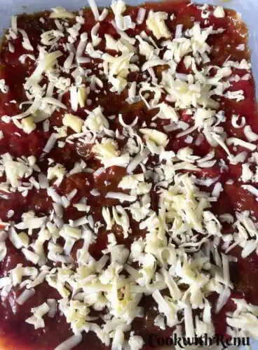 Cheese added on Tomato Sauce on a baking tray.