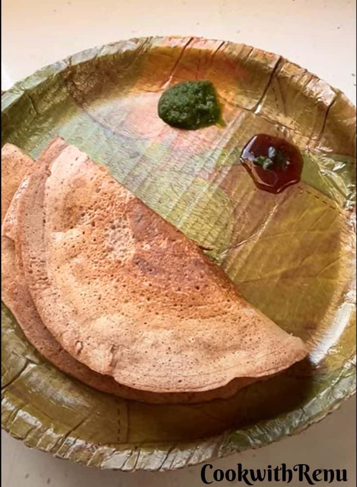 Mix Dal Beetroot Chila served in an eco-friendly plate along with green coriander and tamarind chutney.