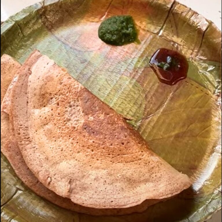 Mix Dal Beetroot Chila served in an eco-friendly plate along with green coriander and tamarind chutney.