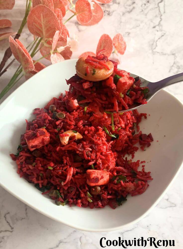 Beetroot Paneer Rice served in a lunchbox along with some cucumber, tomato, and yogurt.
