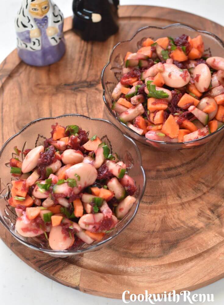 Butter Beans Salad served in 2 glass bowls and kept on a brown cheese board. Seen in the background are salt and pepper shakers.