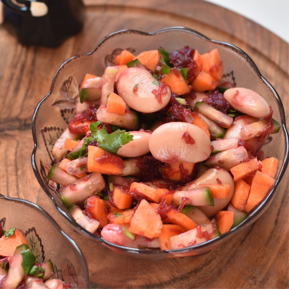 Butter Beans Salad served in 2 glass bowls and kept on a brown cheese board.