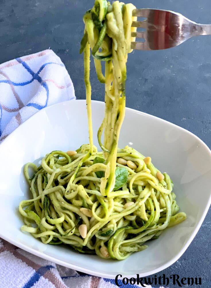 Zoodles salad served in white plate, with zoodles shown.