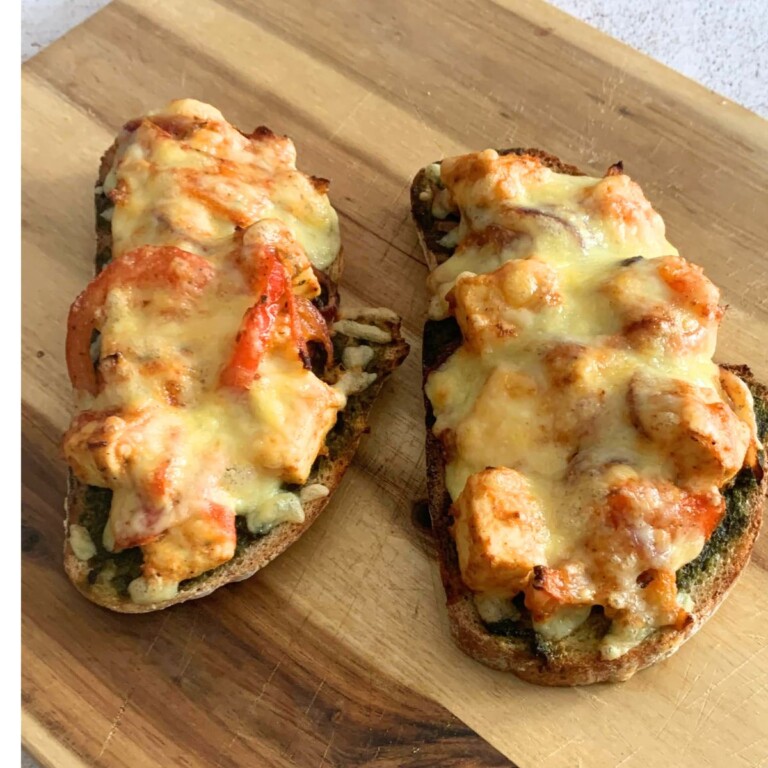 2 slices of Cheese Paneer Tikka Open Sandwich on a cheese board, just baked from air-fryer.