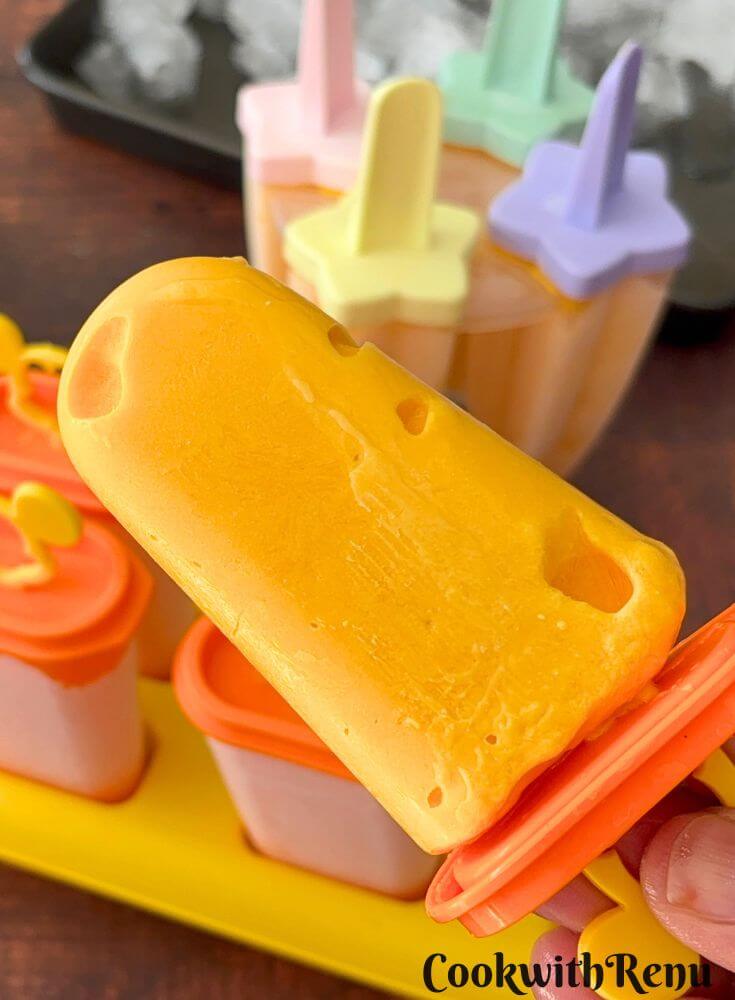 A close-up of a cottage cheese popsicle, with some popsicles in the mold in the background.