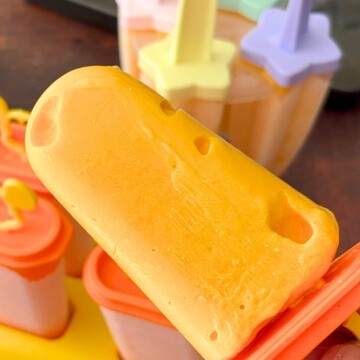 A close-up of a cottage cheese popsicle, with some popsicles in the mold in the background.