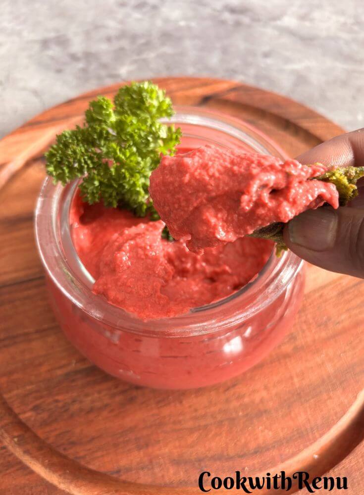 Image showing a close-up look of butter beans, beetroot hummus, dipped in a roti.