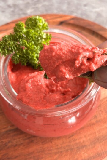 Image showing a close-up look of butter beans, beetroot hummus, dipped in a roti.