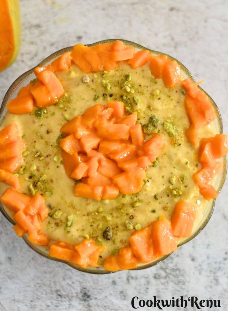 Aamrakhand served in a bowl with a generous garnish of mangoes.