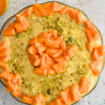 Aamrakhand served in a bowl with a generous garnish of mangoes.