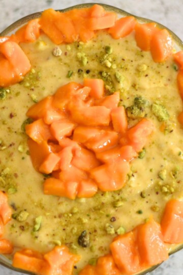 Aamrakhand served in a bowl with a generous garnish of mangoes.