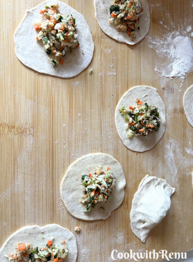 Adding stuffing inside the wrapper on a board.