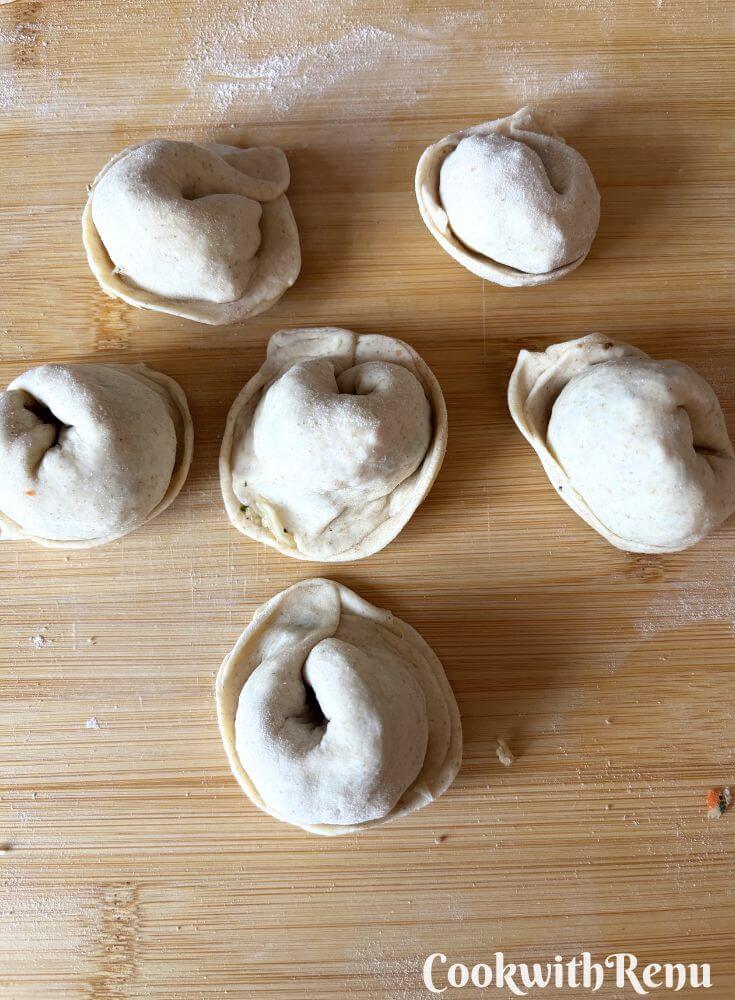 Crescent shaped momos on a board.