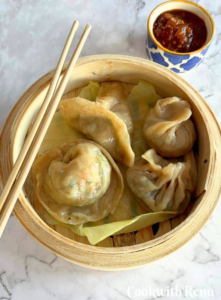 Veg Momos in a momos steamer, along with spicy garlic chutney.