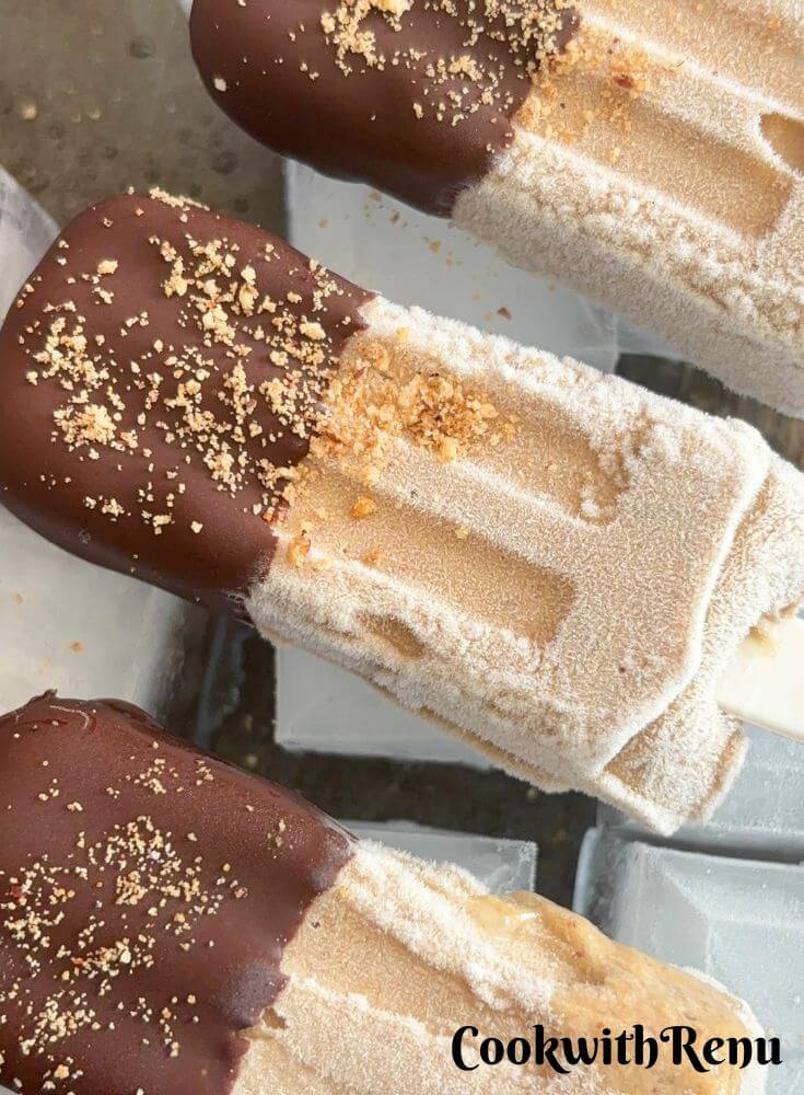 3 Banana Peanut Butter Ice Cream popsicles laid on a Ice Tray.