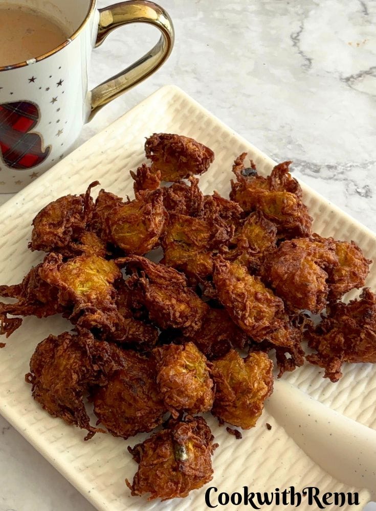 Crispy Dudhi Kofta, served on a white plate along with tea in a cup.