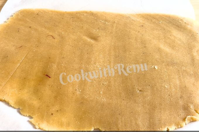 Rolled Badam Burfi Mixture on a parchment paper.