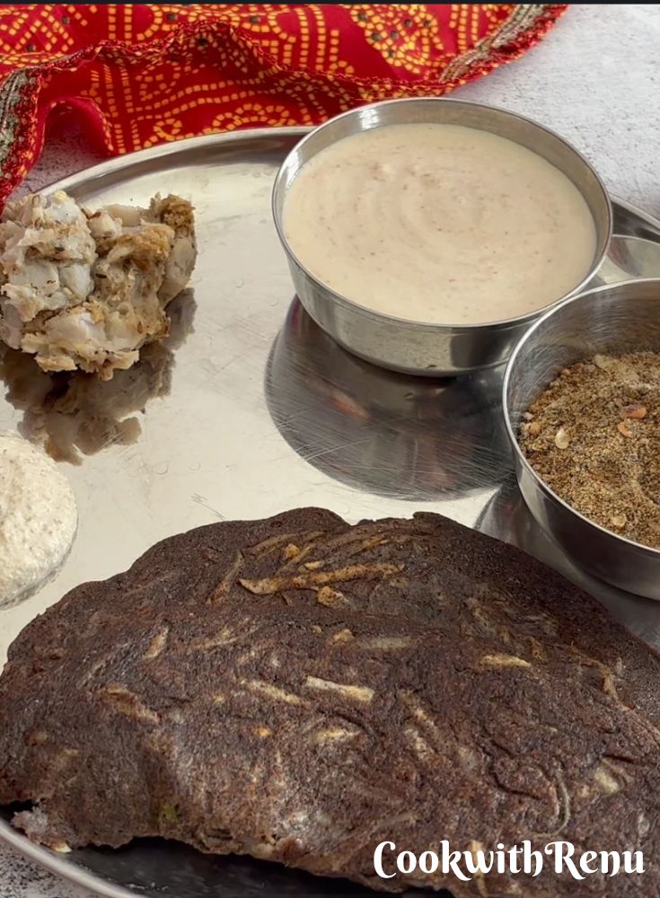 Navratri fasting thali with kuttu aloo cheela and small bowls of farali arbi, yogurt sides, and panjiri.