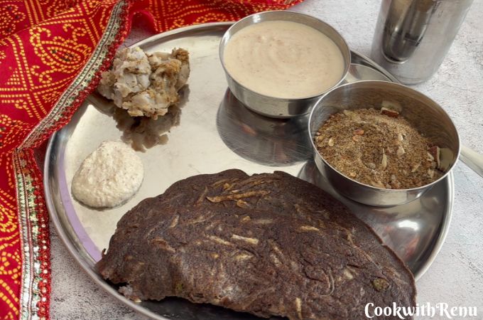 Close-up of a Navratri vrat thali with kuttu aloo cheela, farali arbi, yogurt-based sides, and kuttu panjiri.