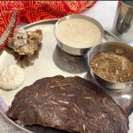 Close-up of a Navratri vrat thali with kuttu aloo cheela, farali arbi, yogurt-based sides, and kuttu panjiri.