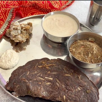 Close-up of a Navratri vrat thali with kuttu aloo cheela, farali arbi, yogurt-based sides, and kuttu panjiri.