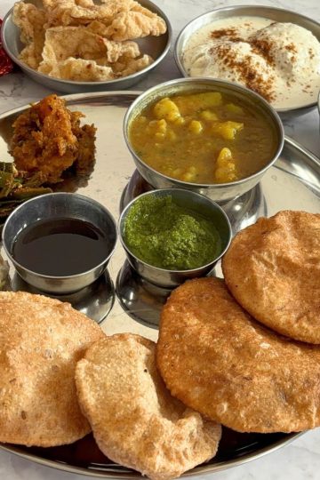 Traditional UP Shradh Thali served with 11 different items in a steel plate with steel bowls.
